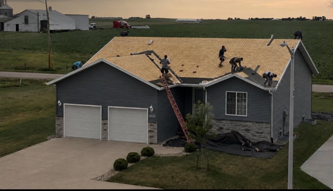 Robertson Roofing crew installing roof decking at sunset